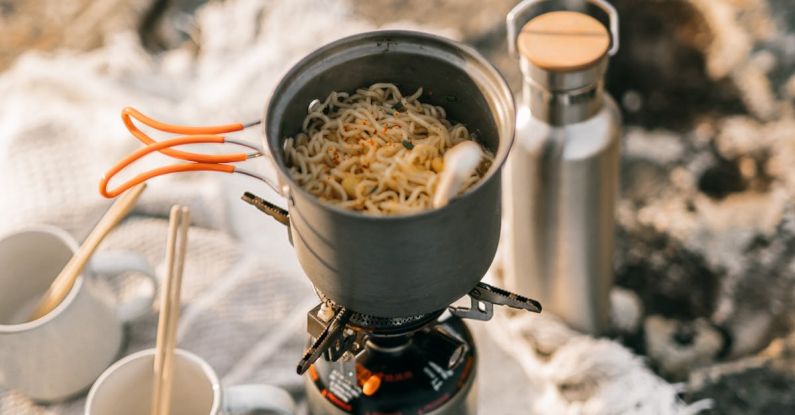 Outdoor Cooking - Cooking Pot with Noodles on a Burning Stove