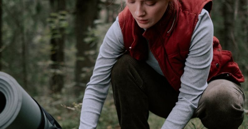 Camping Gear - Woman in Red Gilet Vest Holding a Water Bottle