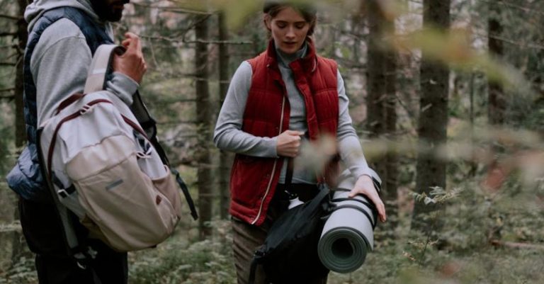 Camping Gear - Woman in Red Gilet Vest Carrying a Gray Sleeping Mat