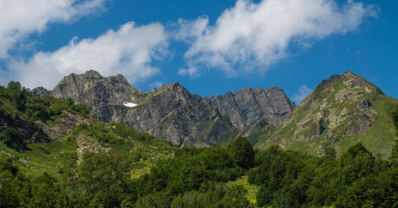 Trail Hike - Mountains in the background with green trees and blue sky