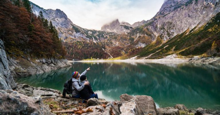 Trail Hike - Couple Sitting on Rock Beside Lake