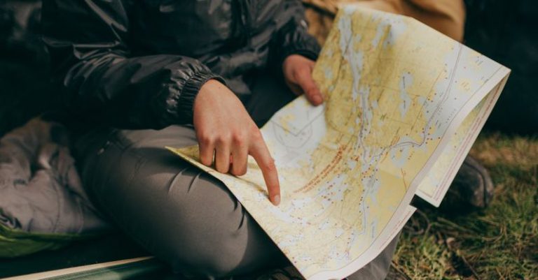 Hike Map - Photo of Woman Sitting While Pointing on World Map