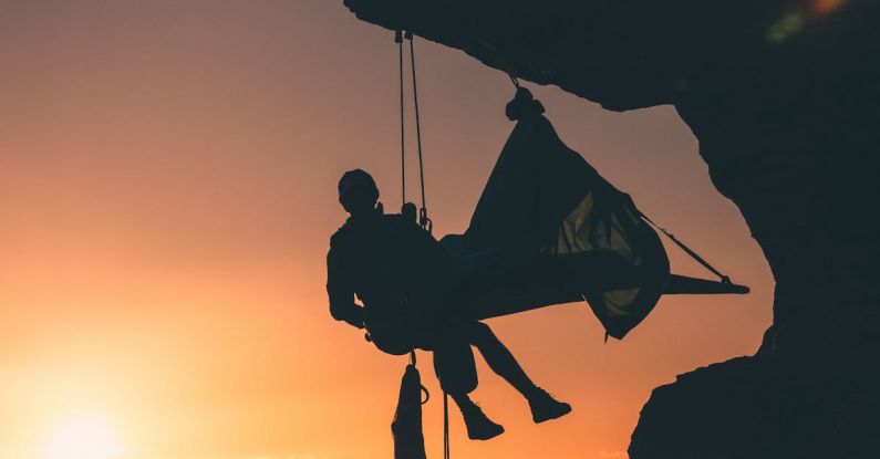 Climbing - Silhouette Photo of Person Hanging by the Cliff