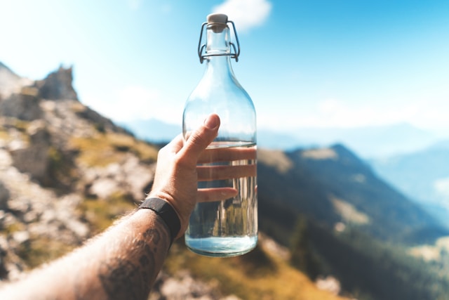 person-holding-empty-clear-glass-bottle
